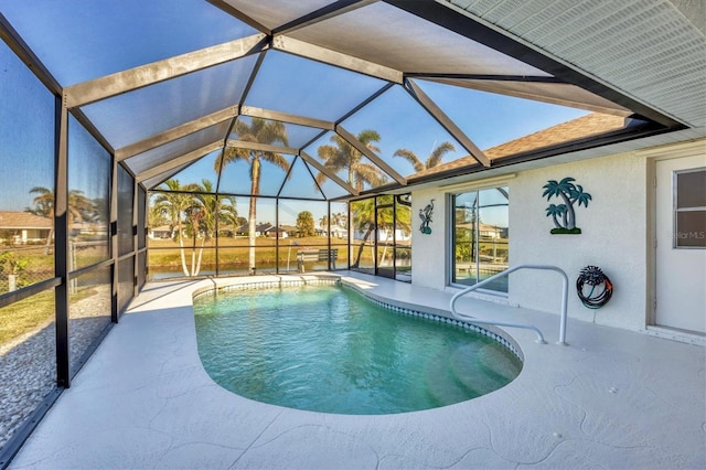 view of pool featuring glass enclosure and a patio area