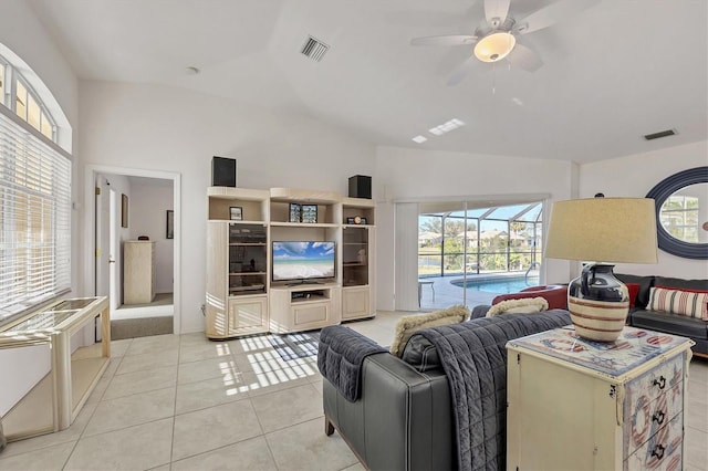 living room with ceiling fan, light tile patterned floors, and vaulted ceiling