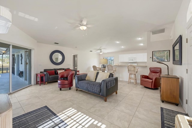 tiled living room featuring vaulted ceiling, a wealth of natural light, and ceiling fan