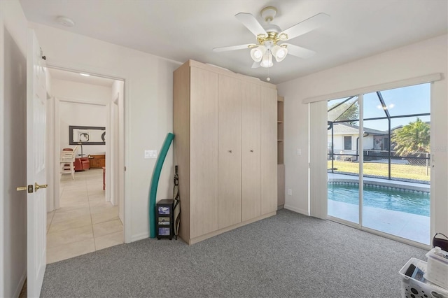 unfurnished bedroom featuring ceiling fan, access to exterior, and light carpet