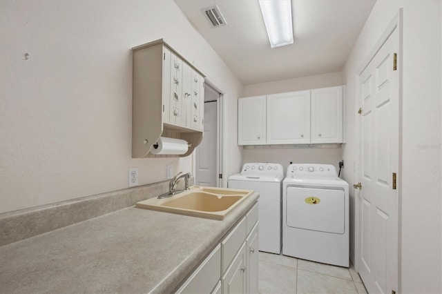 washroom featuring cabinets, light tile patterned floors, washing machine and dryer, and sink