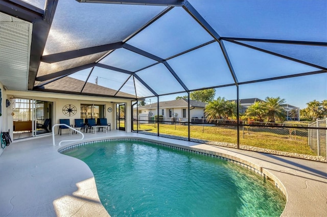 view of pool with glass enclosure and a patio