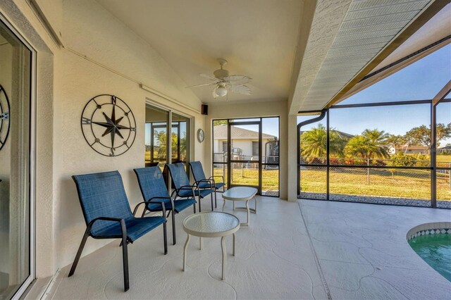 sunroom with ceiling fan and lofted ceiling