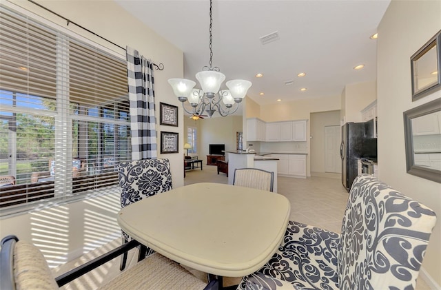 tiled dining room with a chandelier