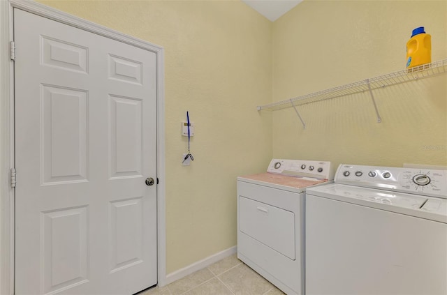 laundry area featuring light tile patterned flooring and washing machine and clothes dryer