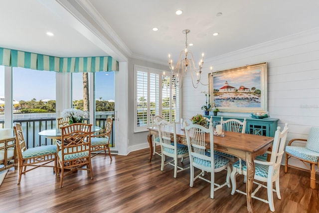 dining area with ornamental molding, dark hardwood / wood-style flooring, and a notable chandelier