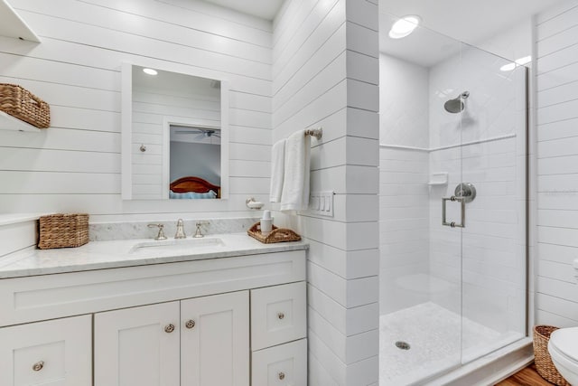 bathroom with vanity, a shower with shower door, and toilet