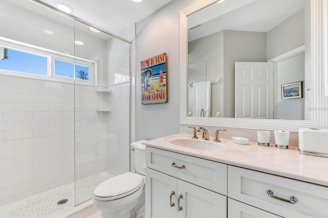 bathroom featuring vanity, an enclosed shower, and toilet