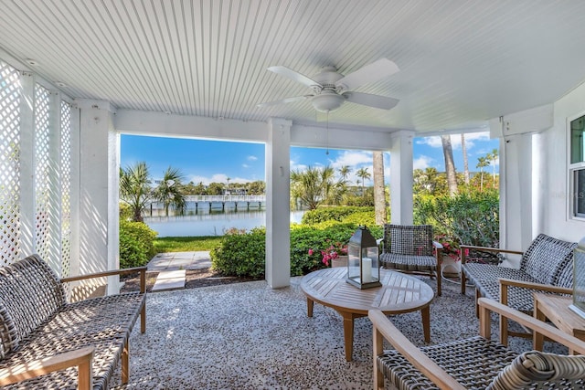 sunroom / solarium with a water view and ceiling fan