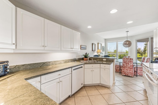 kitchen with pendant lighting, stove, white dishwasher, kitchen peninsula, and white cabinetry