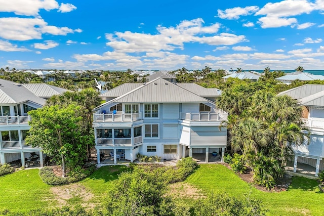 back of property featuring a yard and a balcony