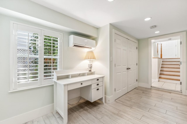 office space featuring a wall unit AC and light hardwood / wood-style flooring