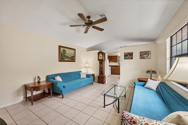 living room featuring a textured ceiling, vaulted ceiling, ceiling fan, and light tile patterned flooring