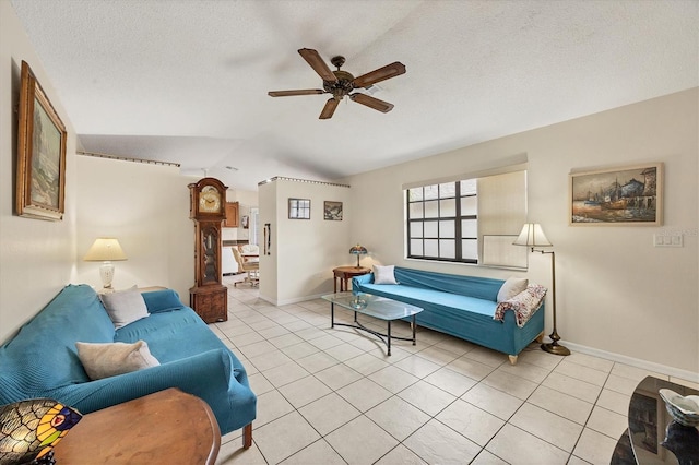 living room with a textured ceiling, ceiling fan, light tile patterned floors, and lofted ceiling