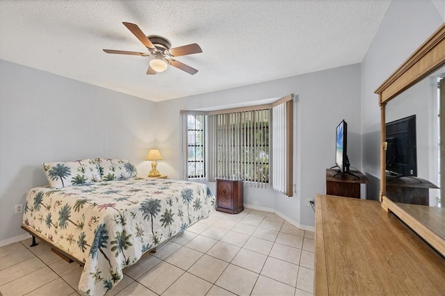 bedroom with ceiling fan, light tile patterned flooring, and a textured ceiling