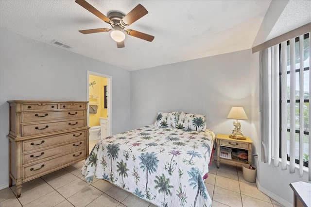 bedroom with light tile patterned floors, a textured ceiling, ensuite bathroom, and ceiling fan