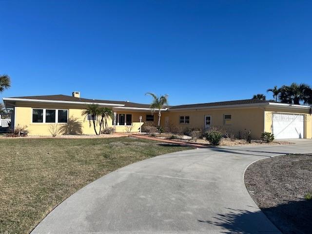 single story home featuring driveway, an attached garage, a front lawn, and stucco siding