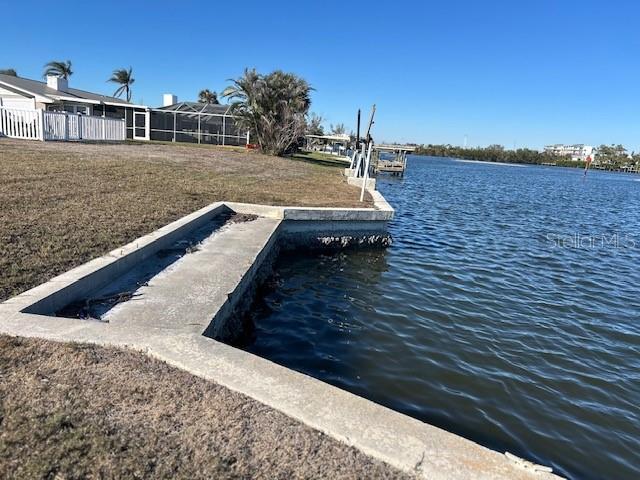 dock area featuring a water view and a lawn