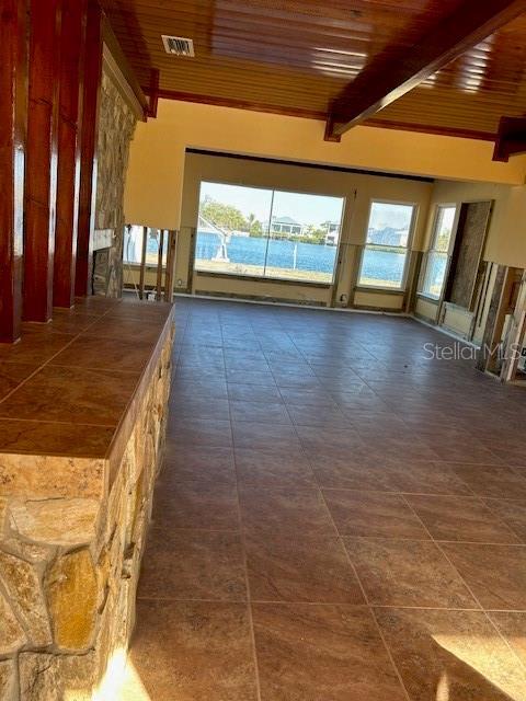 interior space featuring wood ceiling, beamed ceiling, and a water view