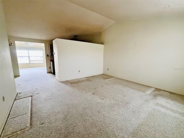 carpeted spare room with ceiling fan, lofted ceiling, and a textured ceiling