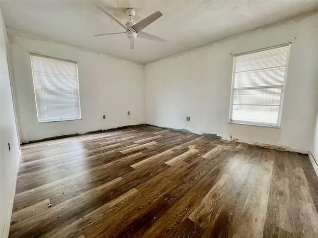 unfurnished room with ceiling fan, wood-type flooring, and a textured ceiling