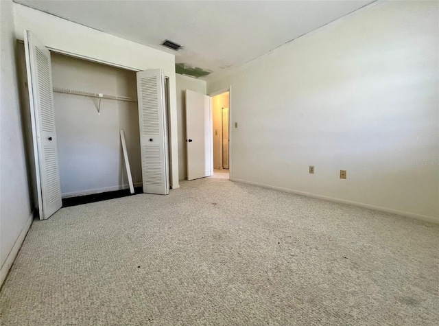 unfurnished bedroom featuring light carpet and a closet