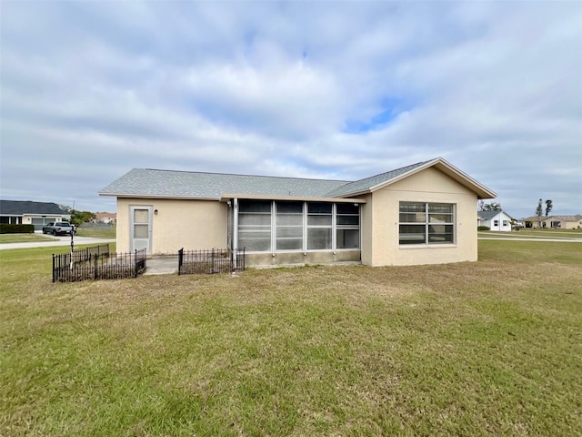 back of property featuring a sunroom and a yard