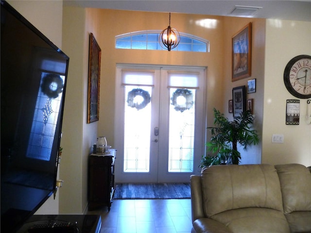 entrance foyer featuring french doors and a notable chandelier