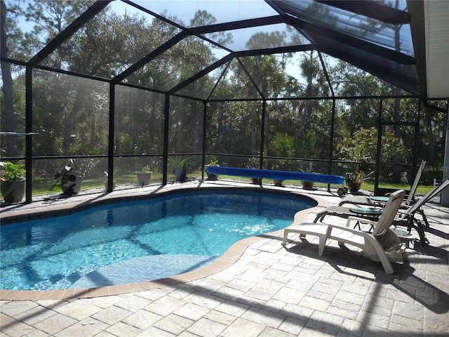 view of pool featuring glass enclosure and a patio area