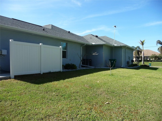 exterior space with central air condition unit and a yard