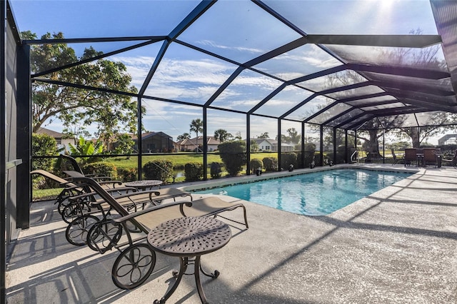 view of pool with glass enclosure and a patio area