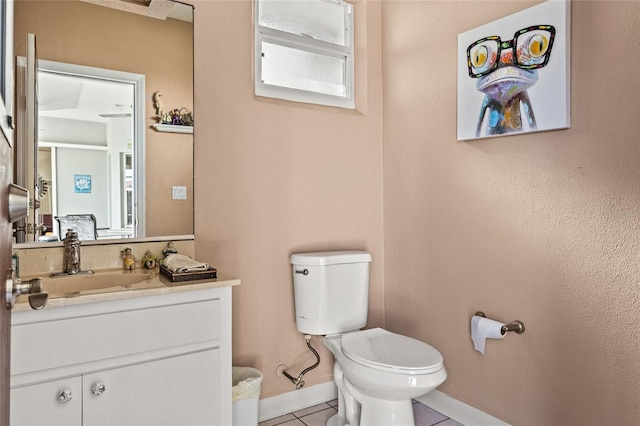 bathroom featuring tile patterned flooring, vanity, and toilet