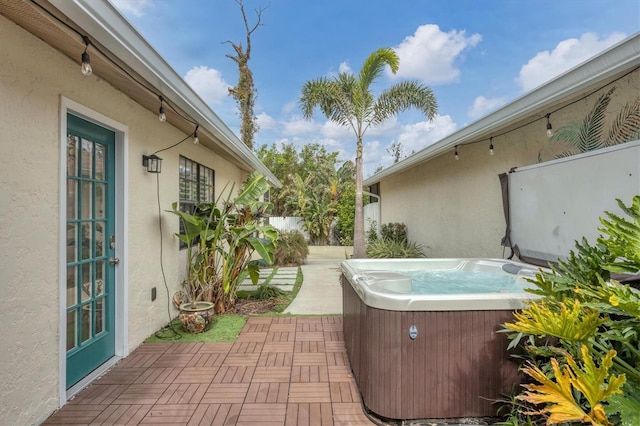 view of patio / terrace with cooling unit and a hot tub