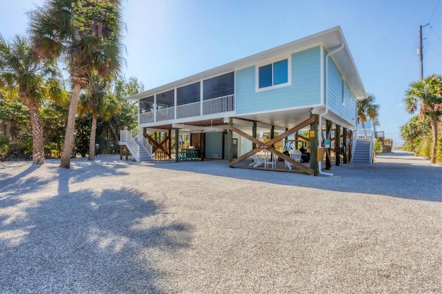 back of house featuring a sunroom and a carport