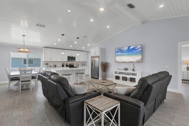 living room featuring vaulted ceiling with beams