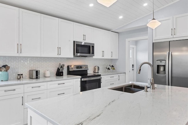 kitchen with light stone countertops, vaulted ceiling, appliances with stainless steel finishes, and sink