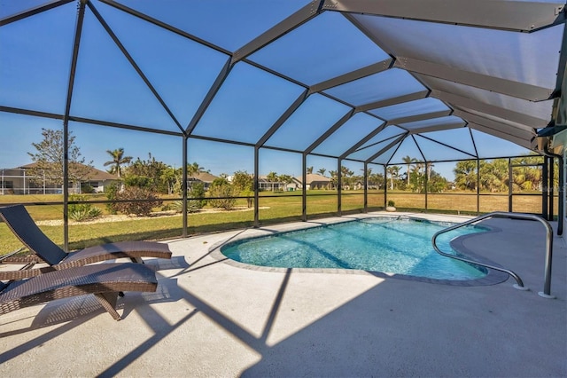 view of pool featuring glass enclosure, a patio area, and a yard