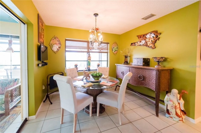 tiled dining area with a textured ceiling and a chandelier