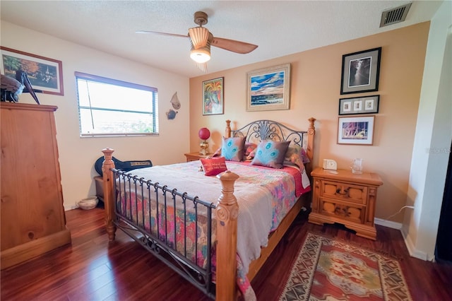 bedroom featuring ceiling fan, dark wood-type flooring, and a textured ceiling