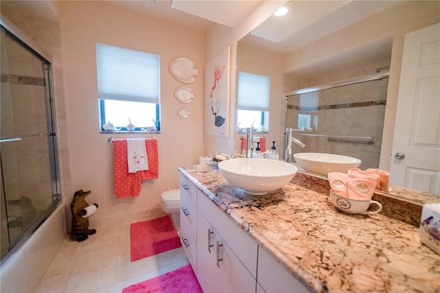 full bathroom featuring tile patterned flooring, vanity, toilet, and enclosed tub / shower combo