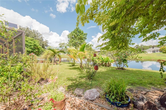 view of yard with a water view and a lanai