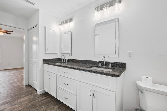 bathroom with toilet, ceiling fan, and vanity