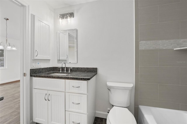 bathroom featuring toilet, hardwood / wood-style floors, a chandelier, and vanity