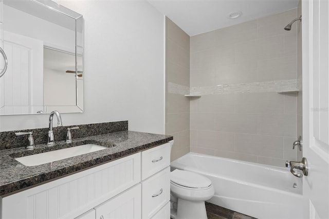 full bathroom with toilet, tiled shower / bath, and vanity