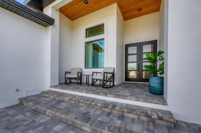 view of exterior entry with french doors and covered porch