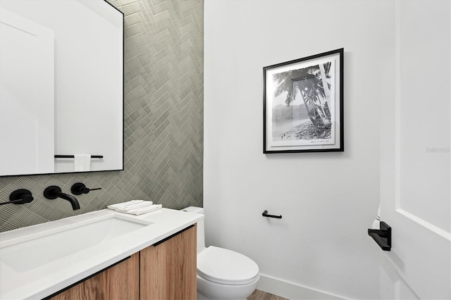 bathroom featuring backsplash, toilet, and vanity