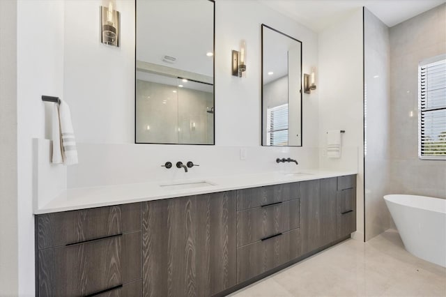 bathroom featuring vanity, tile patterned flooring, and a washtub