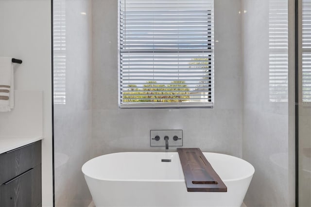 bathroom featuring a bathing tub, tile walls, and vanity