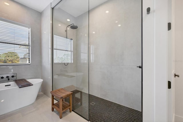 bathroom with tile walls and shower with separate bathtub