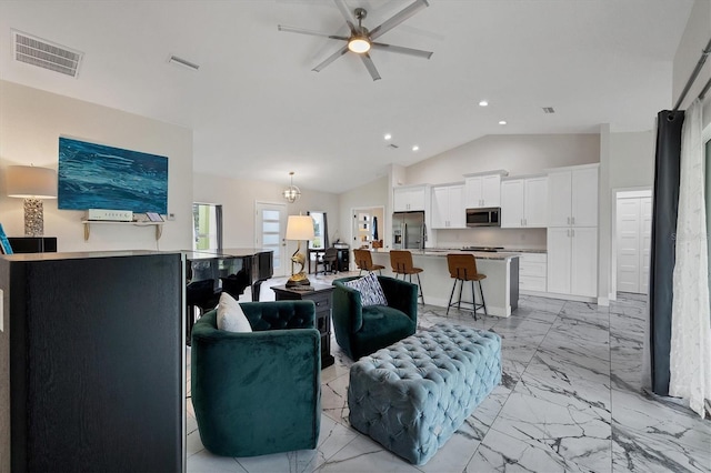 living room with lofted ceiling and ceiling fan with notable chandelier